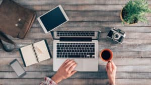 man working on laptop with coffee at desk