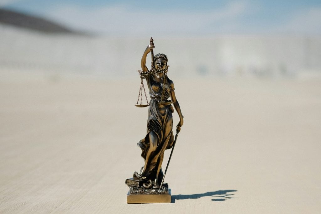 Bronze statue of Lady Justice holding scales, symbolizing legal considerations in starting an LLC​