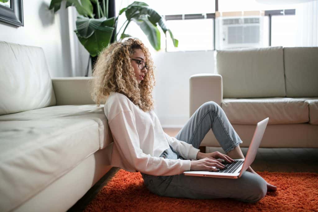 Image of a woman sitting on the floor working on her company learning how to start an LLC