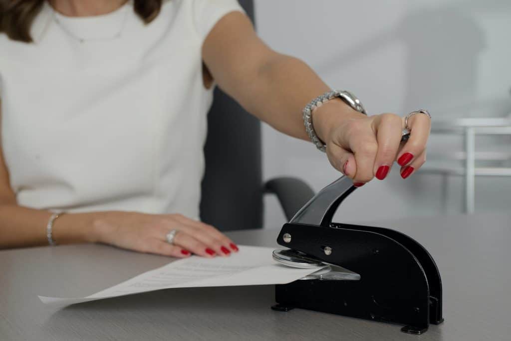 Woman in white dress applying a notary seal to a document for one of the best online notary services