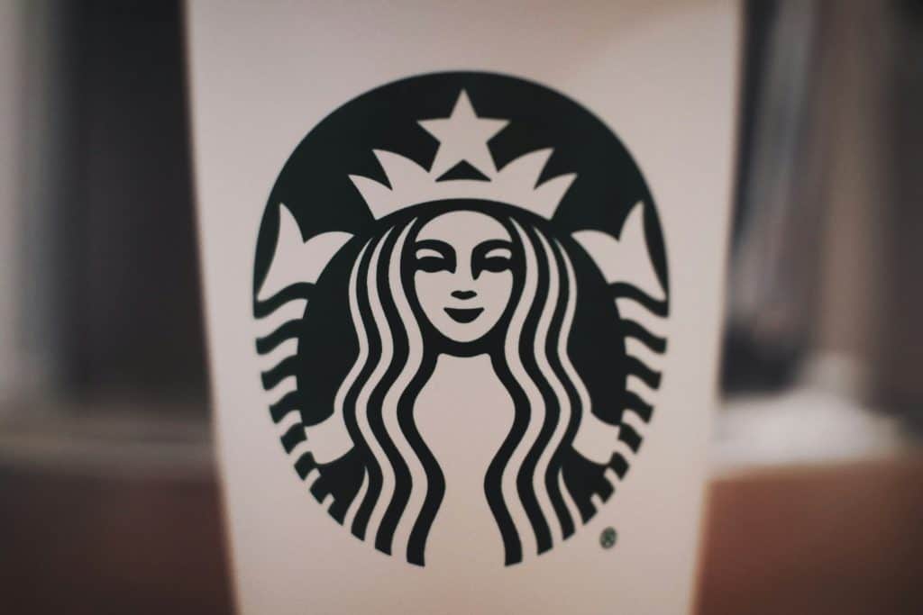 Starbucks coffee cup on a wooden table with trademarked logo – TM vs R