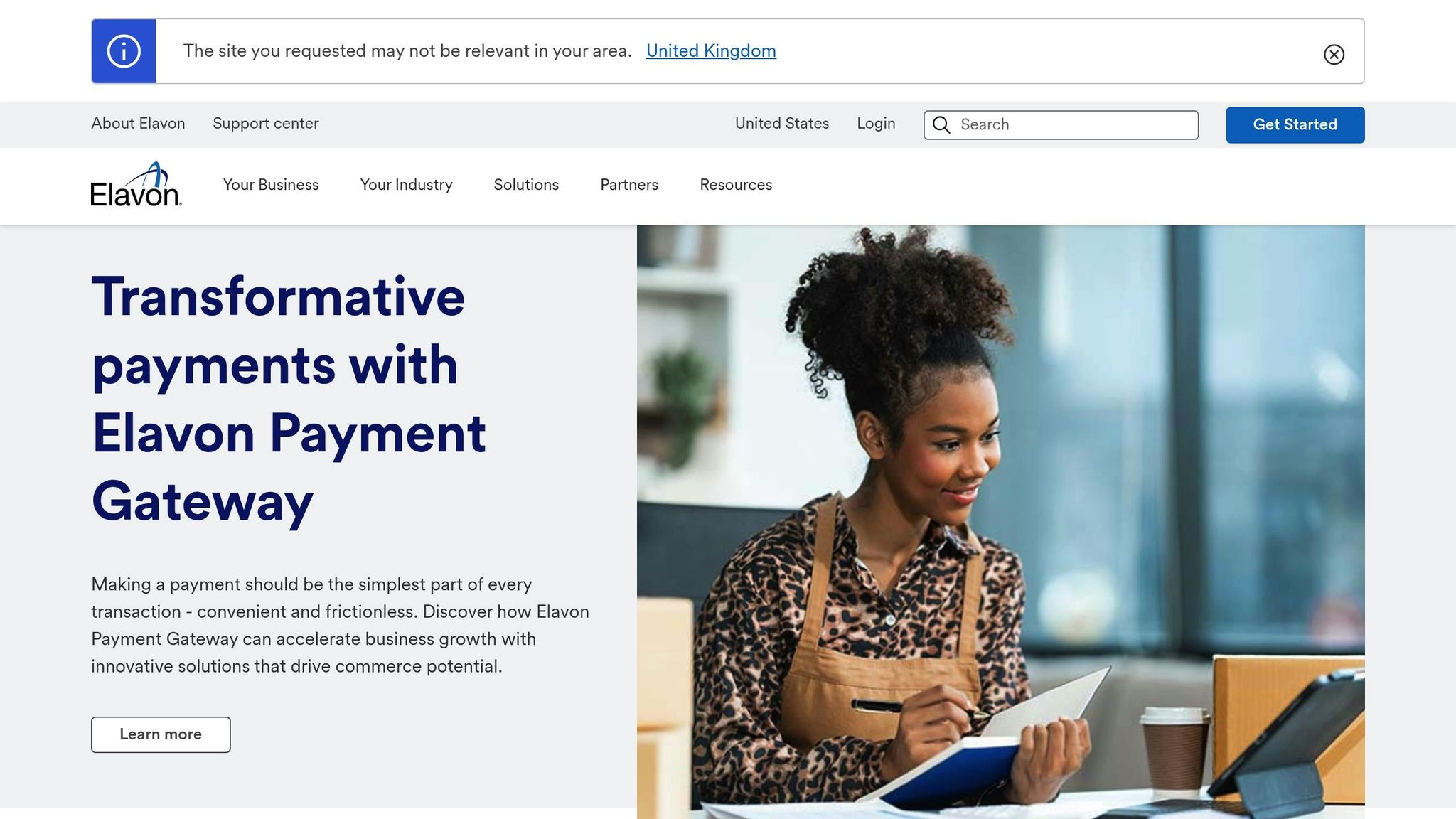 Young woman using a tablet with a payment terminal on a desk, representing innovative payment solutions with Elavon Payment Gateway.