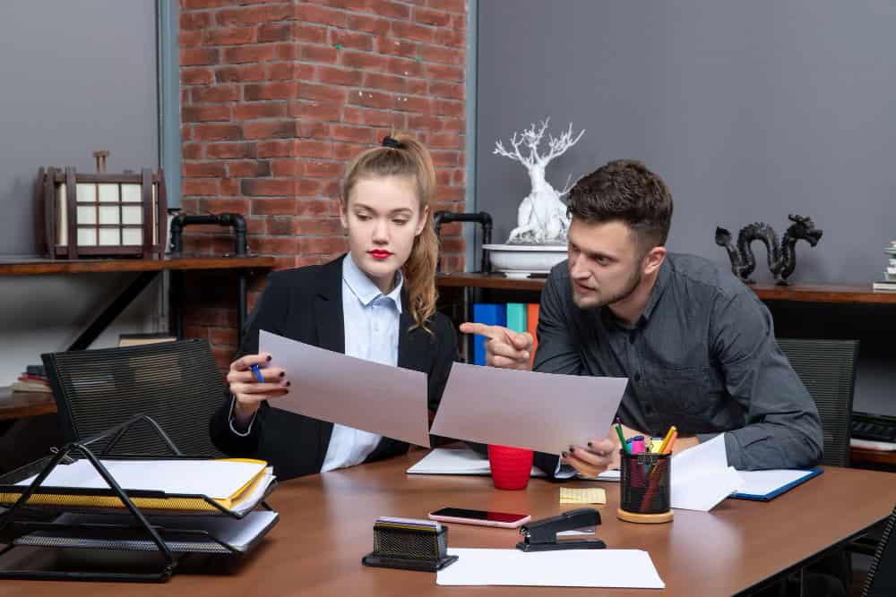 Flexible remote working and business collaboration with professionals analyzing documents in a modern office environment.