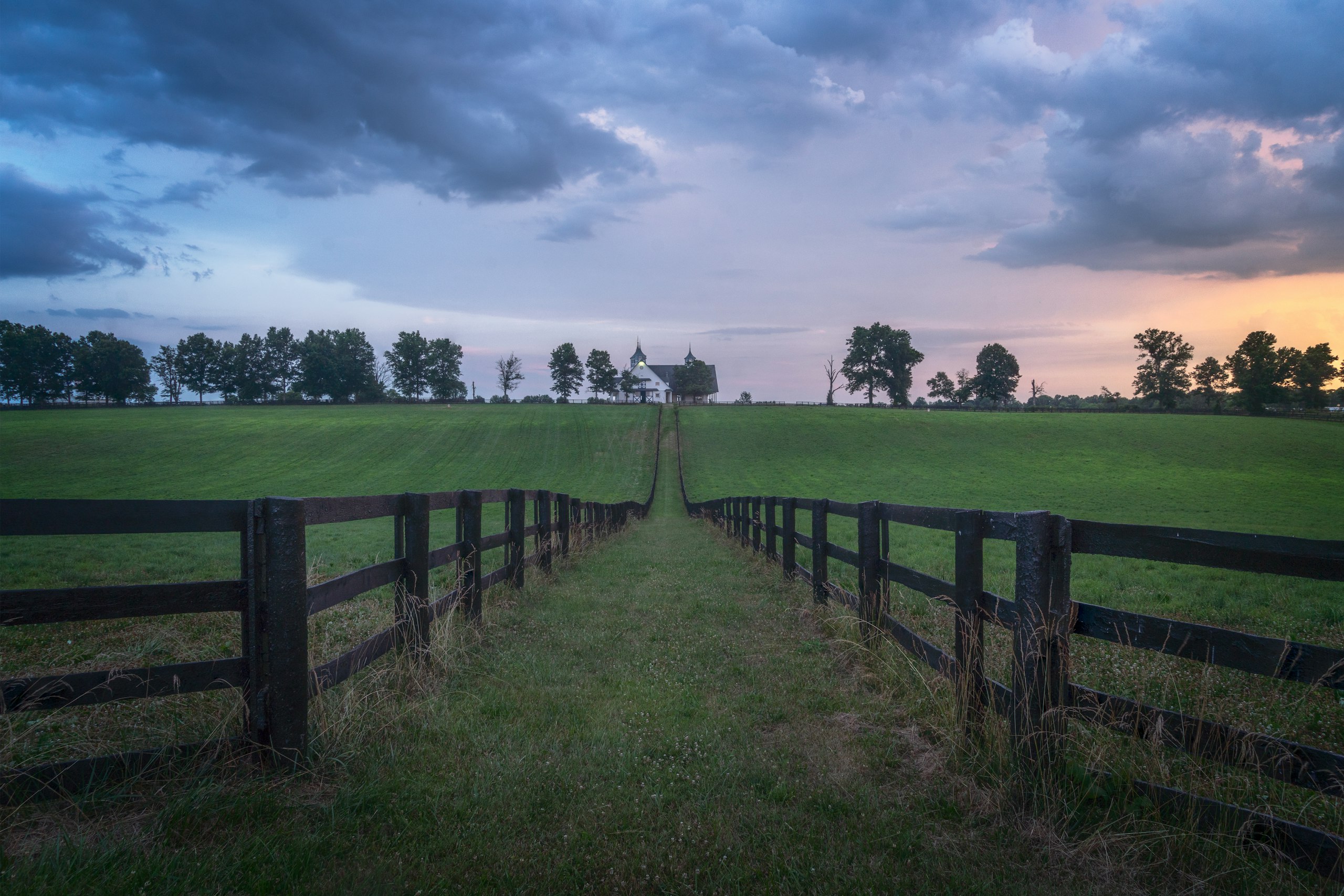 Kentucky horse farm with wooden fences at dusk